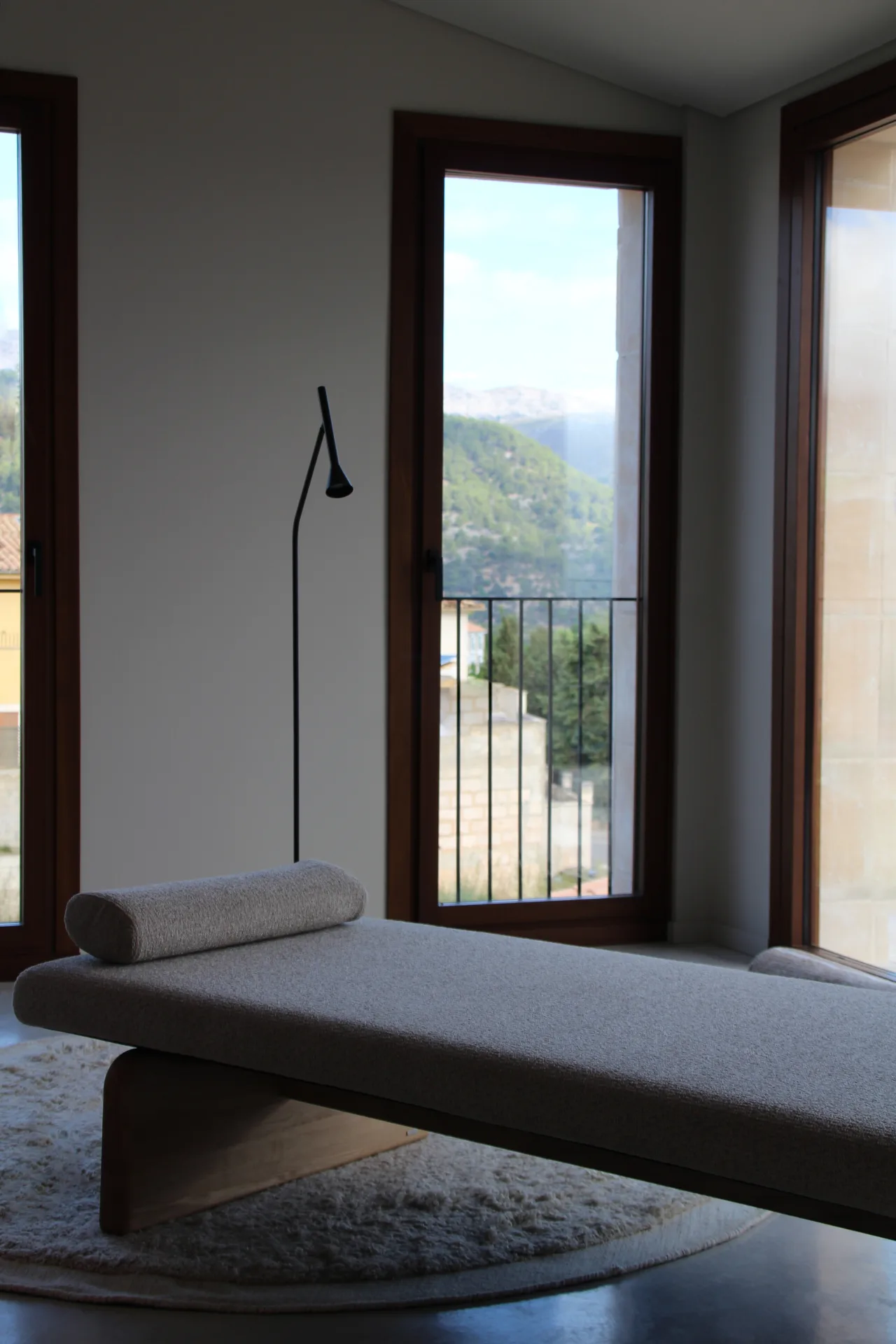 Banco tapizado junto a un ventanal con vistas en una casa de Campanet Banco tapizado junto a un ventanal con vistas en una casa de Campanet