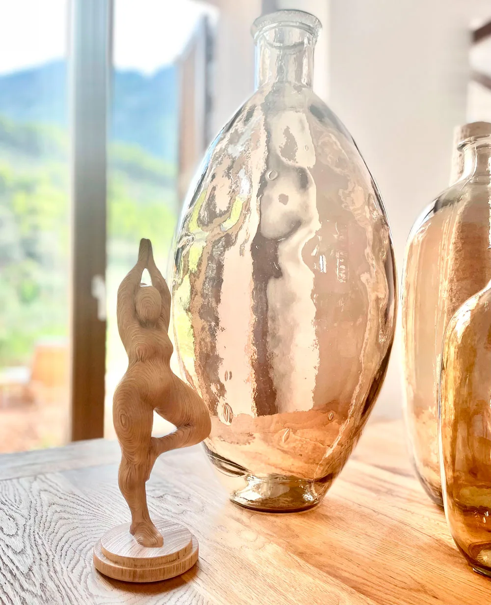 Botellas de cristal ámbar y figura de madera sobre la mesa Botellas de cristal ámbar y figura de madera sobre la mesa