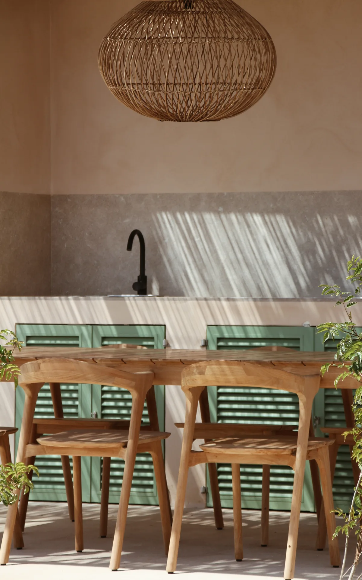 Cocina exterior con lámpara de fibra y sillas de madera en Sa Ràpita Cocina exterior con lámpara de fibra y sillas de madera en Sa Ràpita
