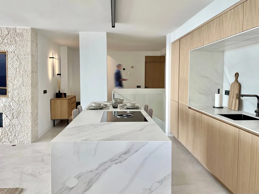 Cocina con isla de mármol y muebles de madera Cocina con isla de mármol y muebles de madera