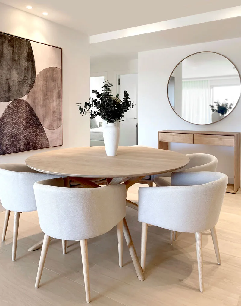 Comedor con mesa redonda y sillas tapizadas en un piso de Sa Teulera