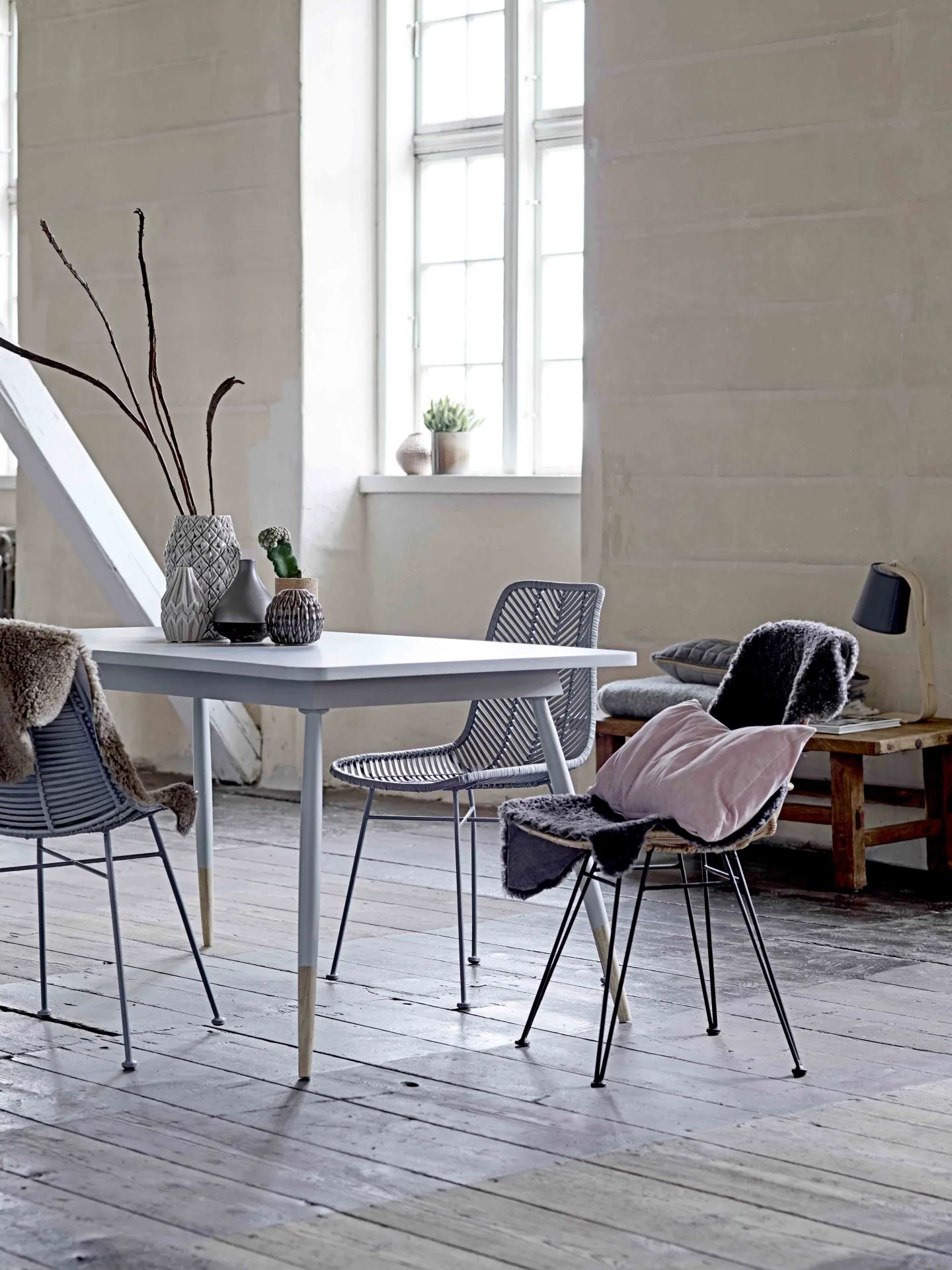 Nordic dining room with a white table, wire chairs and natural light