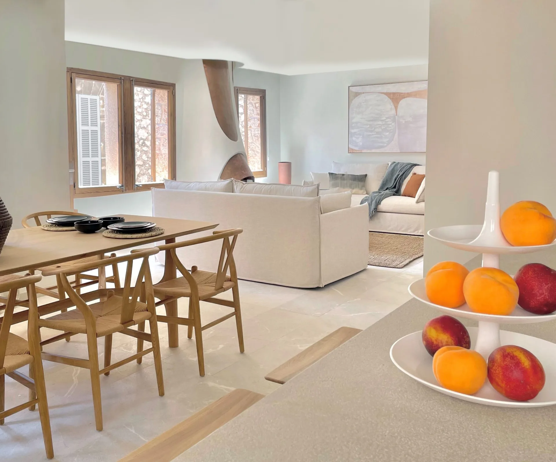 Comedor con sillas de madera y frutero en una casa modernista de Pollença