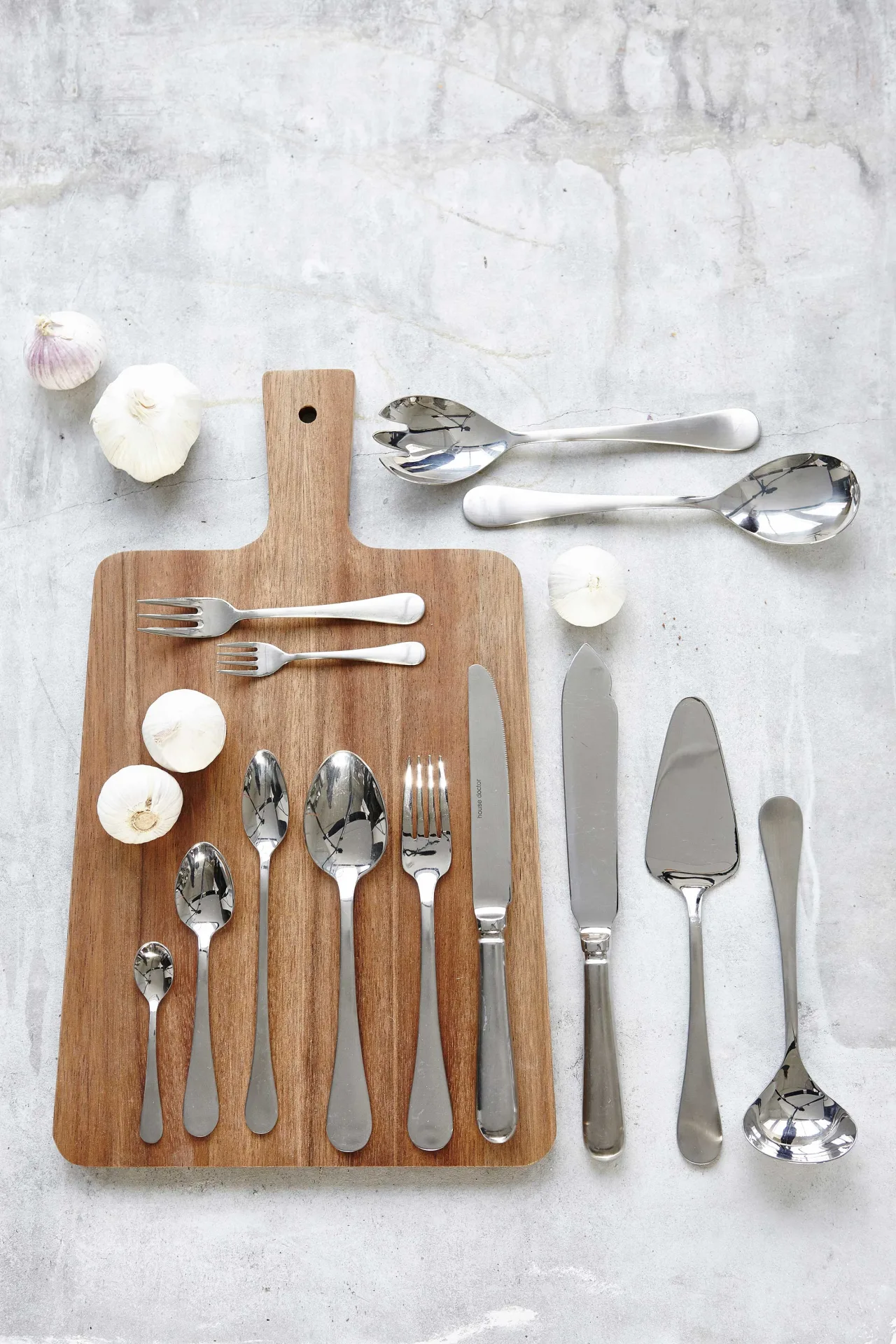Stainless steel cutlery on a wooden chopping board
