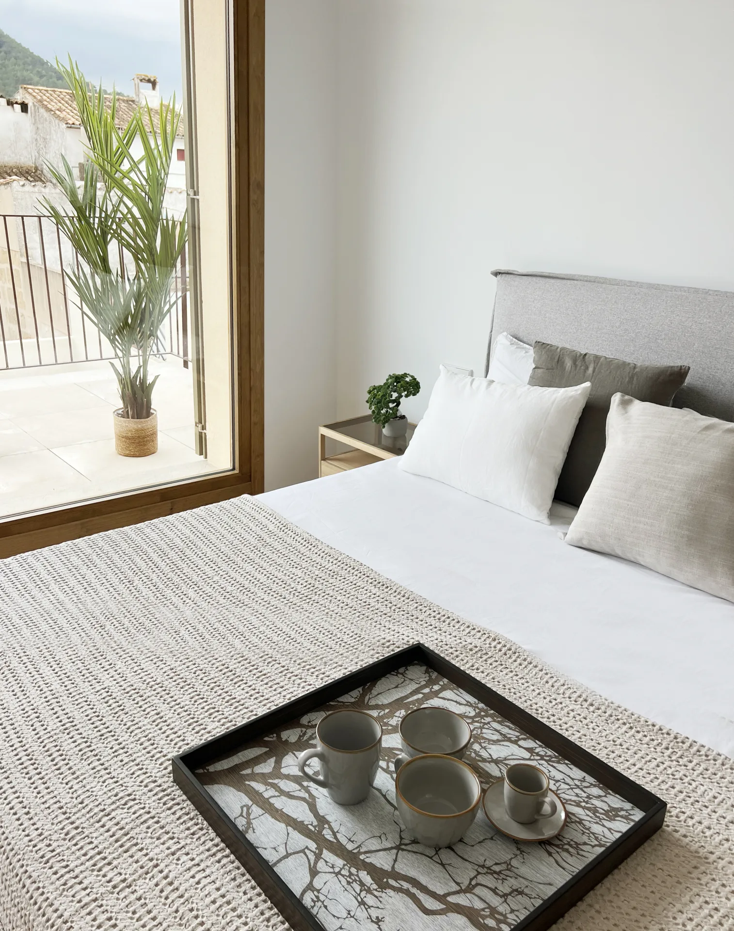 Dormitorio con bandeja de té sobre la cama y vistas al pueblo Dormitorio con bandeja de té sobre la cama y vistas al pueblo