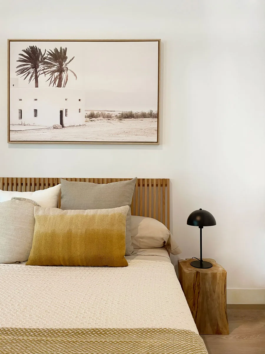Dormitorio con cabecero de madera y cuadro de palmeras Dormitorio con cabecero de madera y cuadro de palmeras