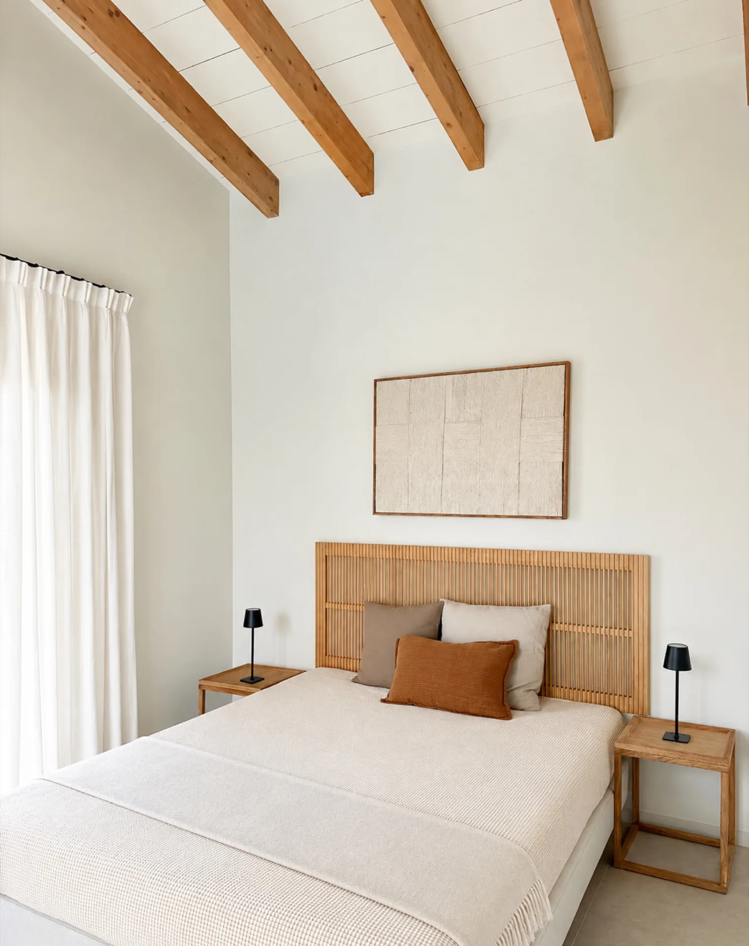 Dormitorio con cabecero de madera y vigas vistas en una casa de Sineu Dormitorio con cabecero de madera y vigas vistas en una casa de Sineu