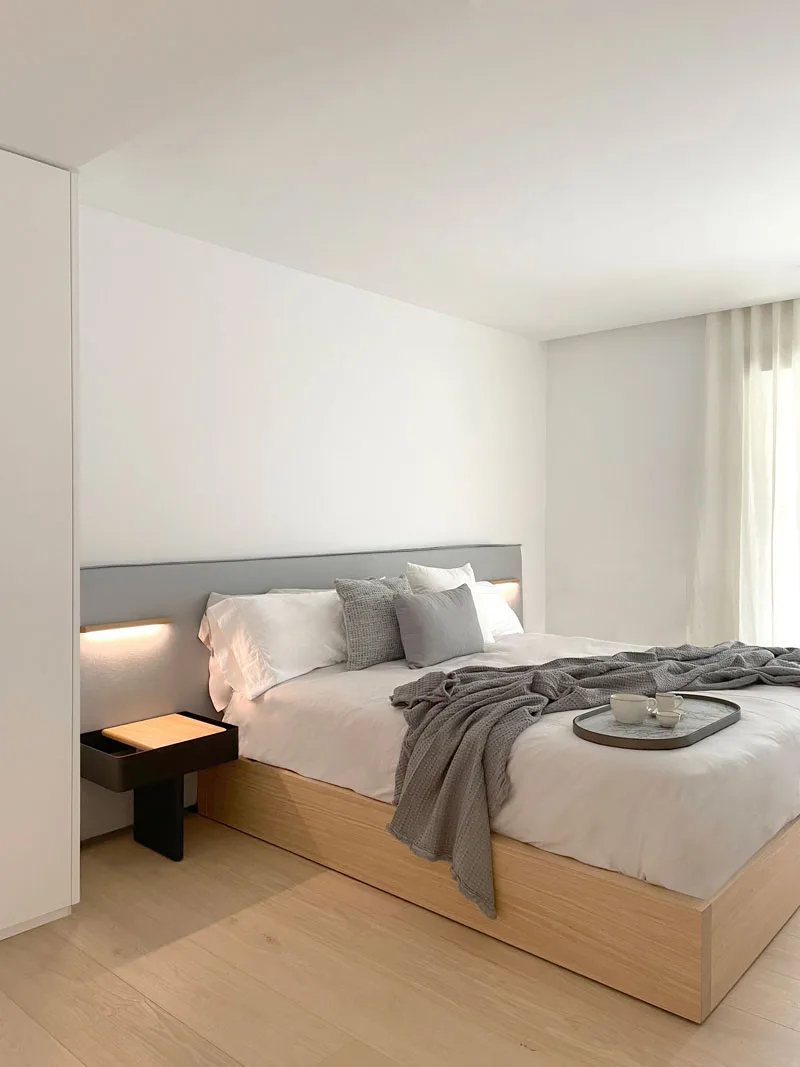 Dormitorio con cama de madera y manta gris Dormitorio con cama de madera y manta gris