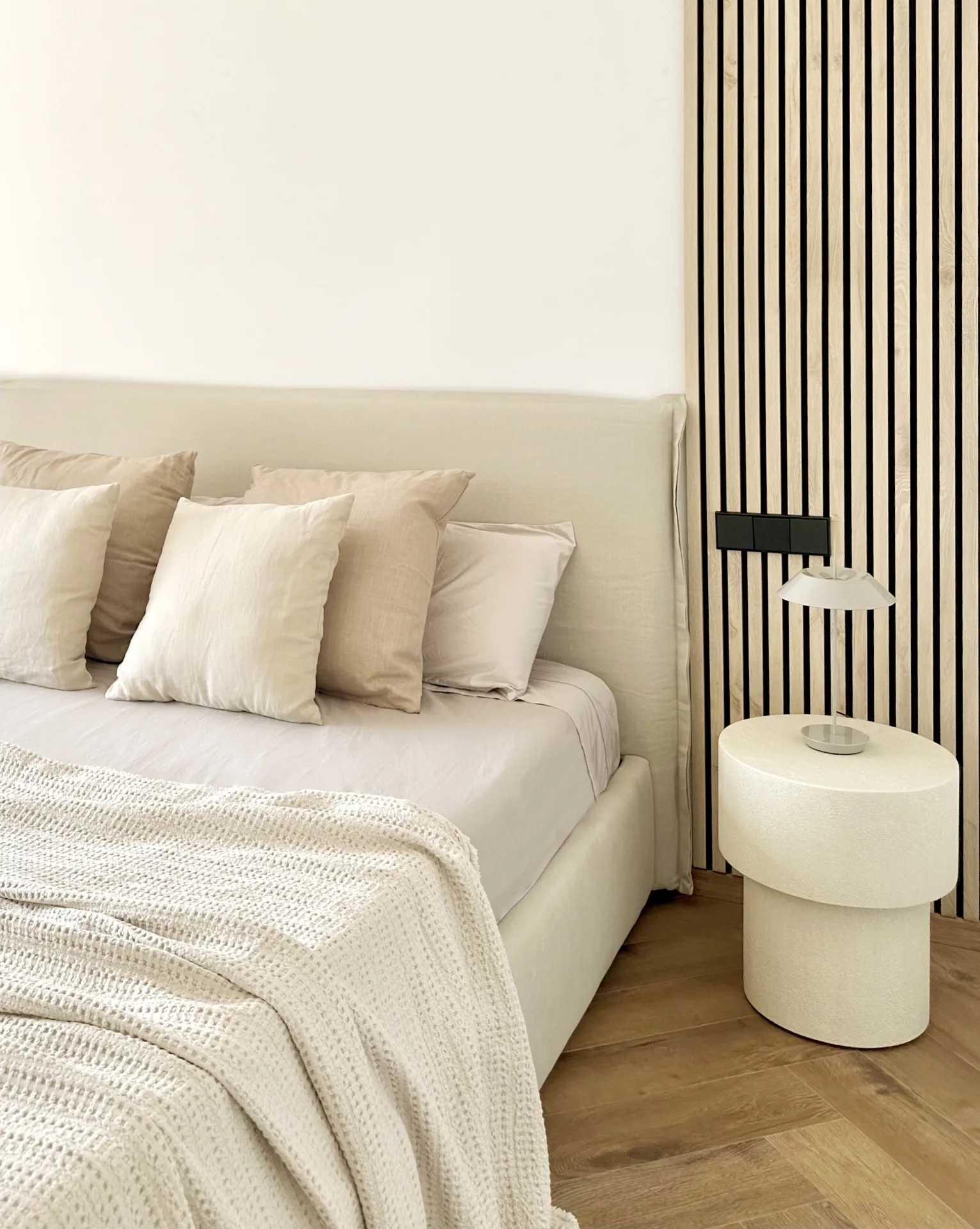 Dormitorio con cama tapizada y mesilla blanca Dormitorio con cama tapizada y mesilla blanca