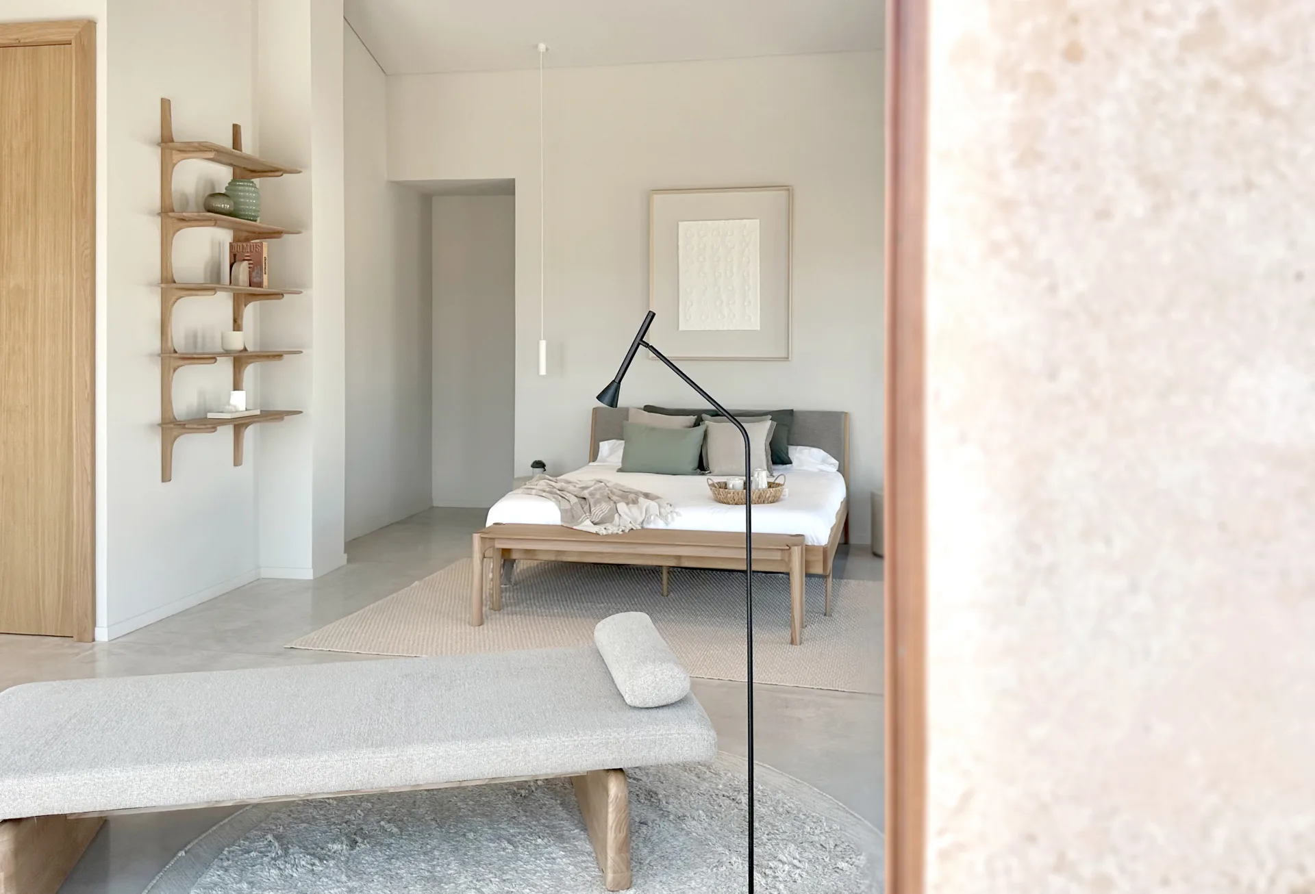 Dormitorio con estantes de madera y banco a los pies de la cama Dormitorio con estantes de madera y banco a los pies de la cama