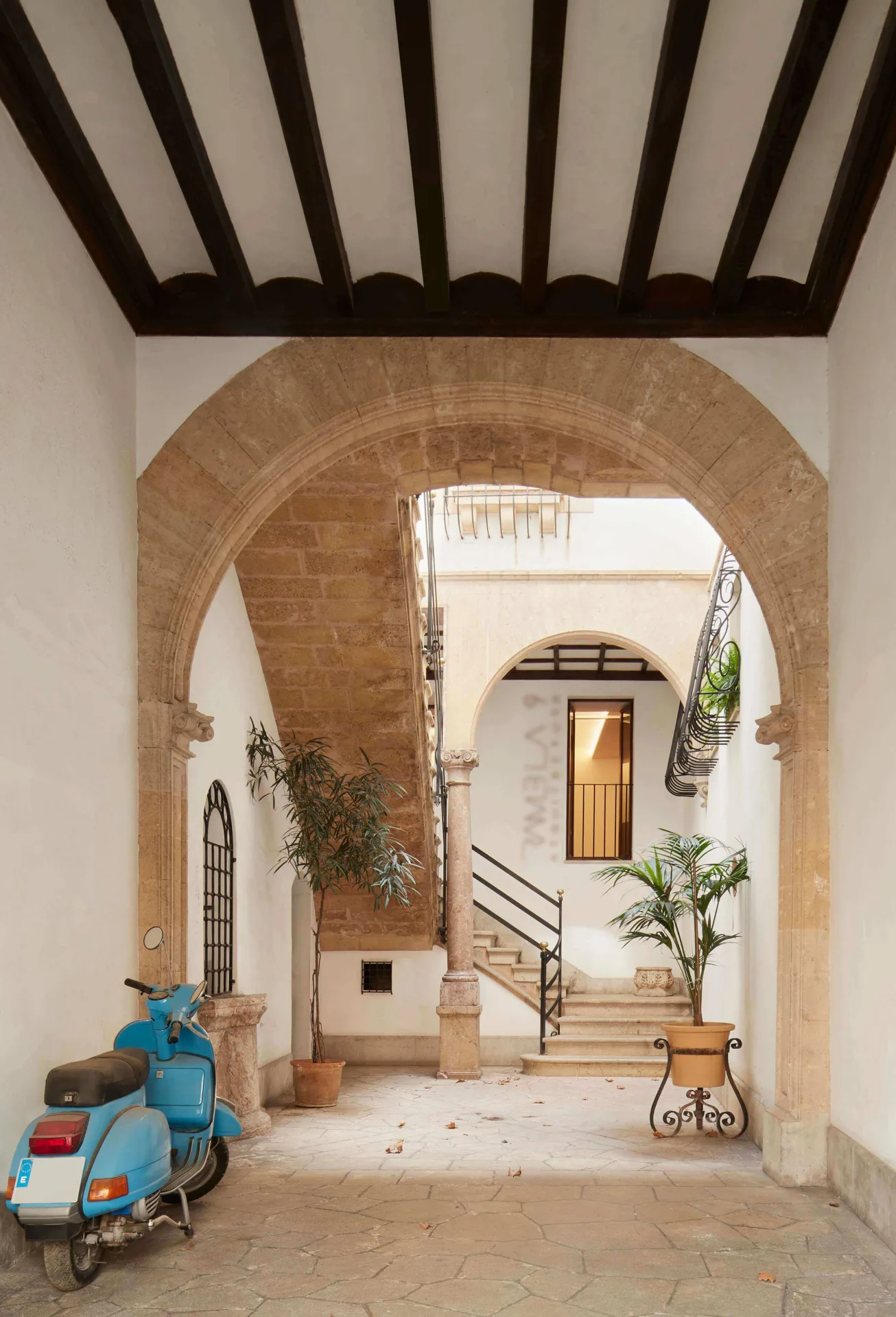 Eingang eines herrschaftlichen Hauses in Palma mit Bögen aus Marès-Stein, Holzbalken und Treppe zum Innenhof