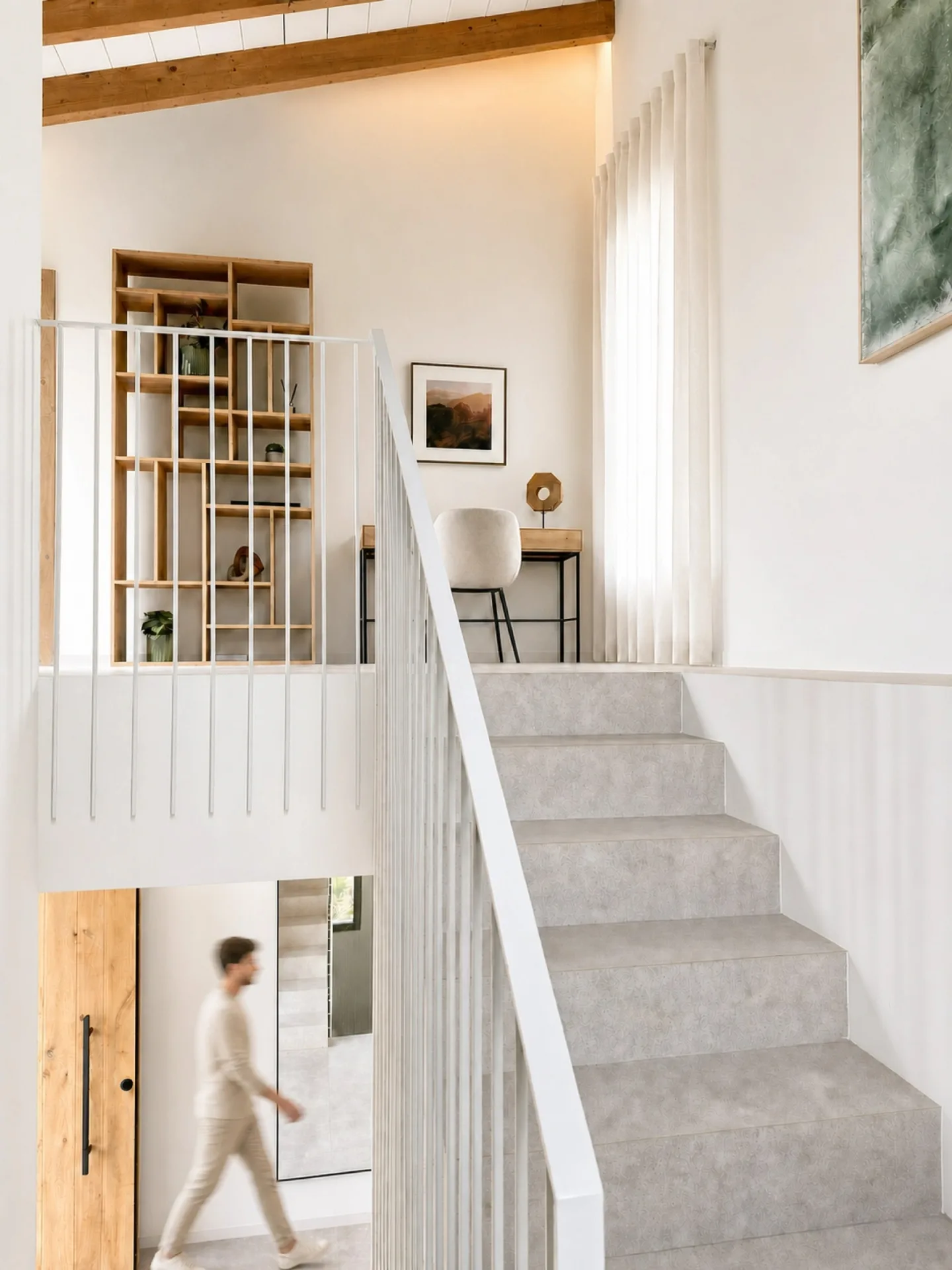 Escalera blanca y estantería de madera en el recibidor de una vivienda en Sineu