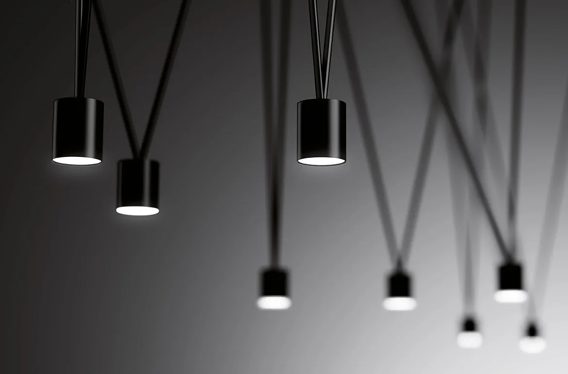 Black Vibia pendant spotlights hanging on long cables
