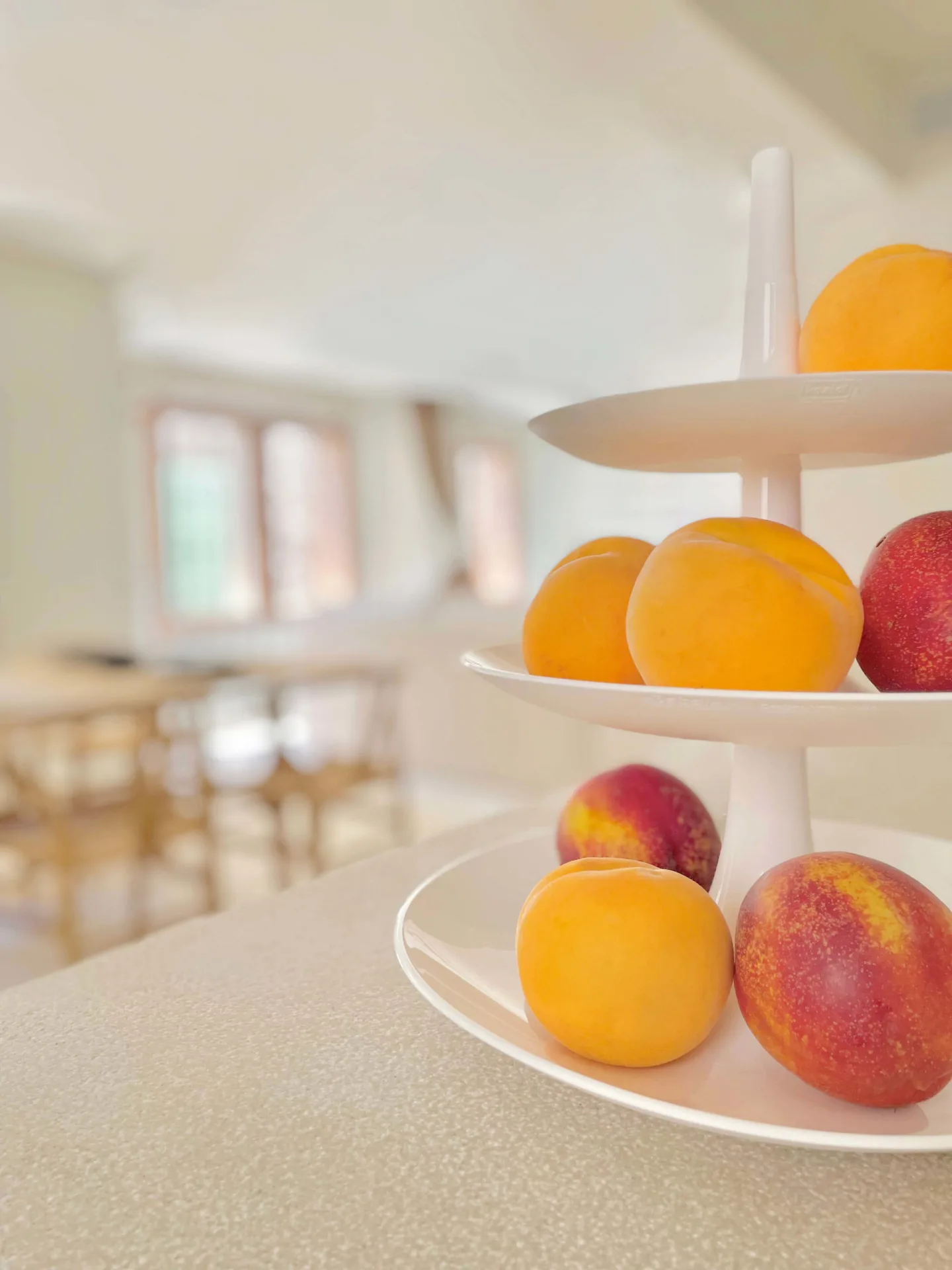 Frutero con naranjas y melocotones sobre la mesa Frutero con naranjas y melocotones sobre la mesa