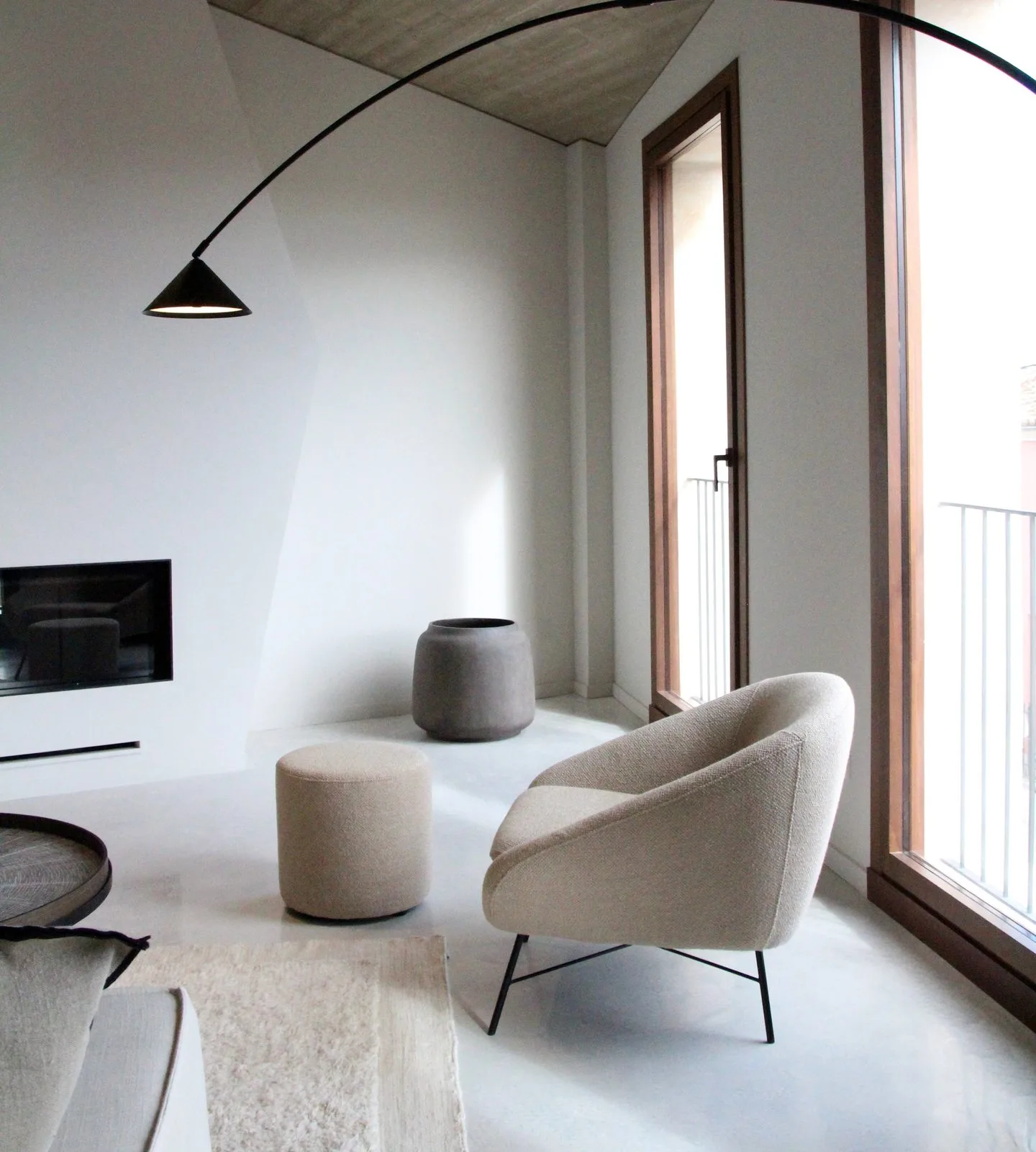 interiorismo-salon-butaca-lampara-arco Salón con butaca bouclé, puf, lámpara de arco y ventanal de madera