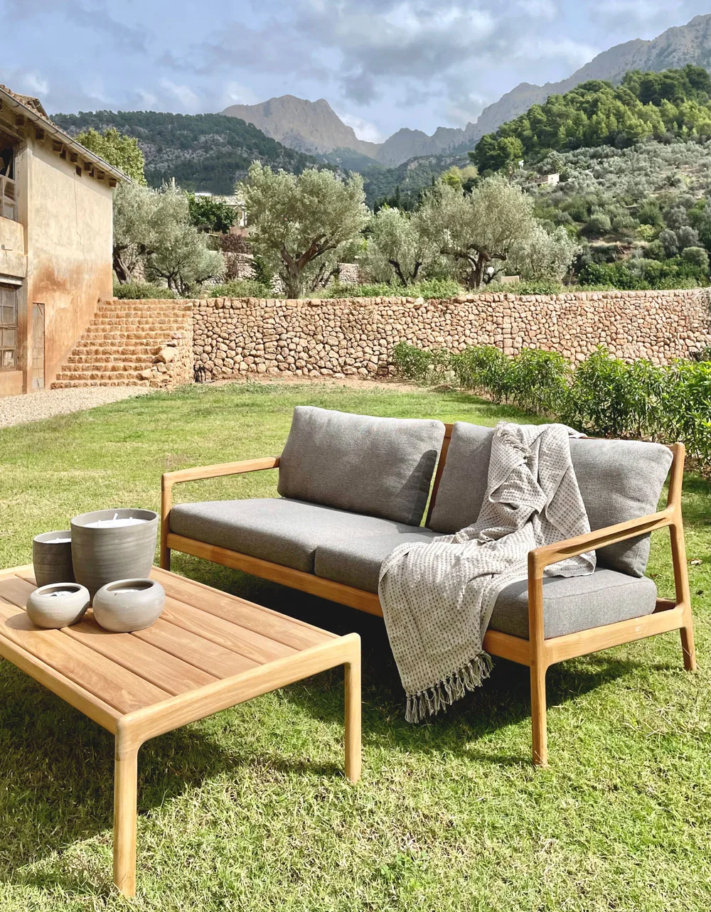 Jardín con sofá de madera y vistas a la Serra de Tramuntana en Fornalutx