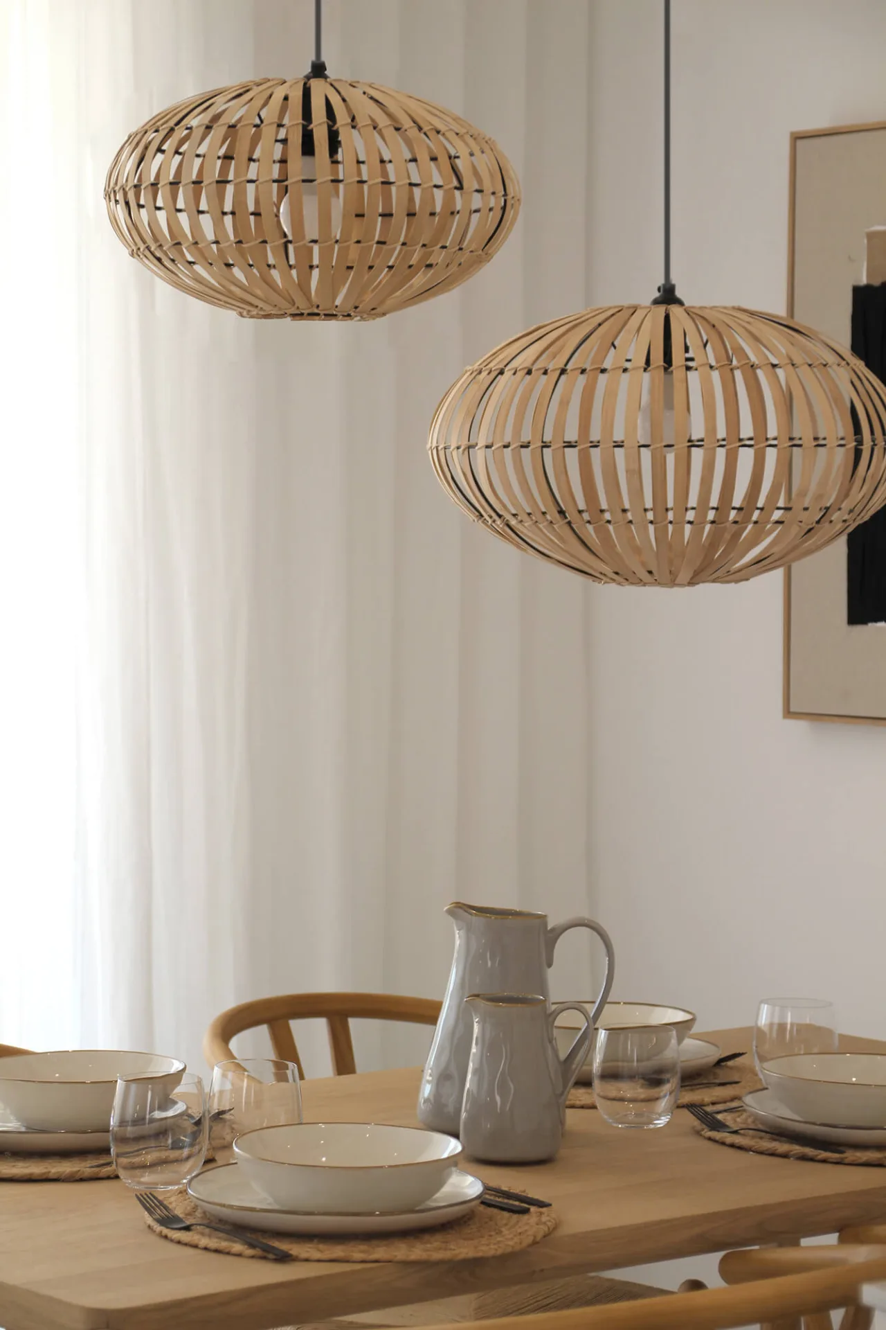 Lámparas de mimbre sobre mesa de comedor puesta Lámparas de mimbre sobre mesa de comedor puesta