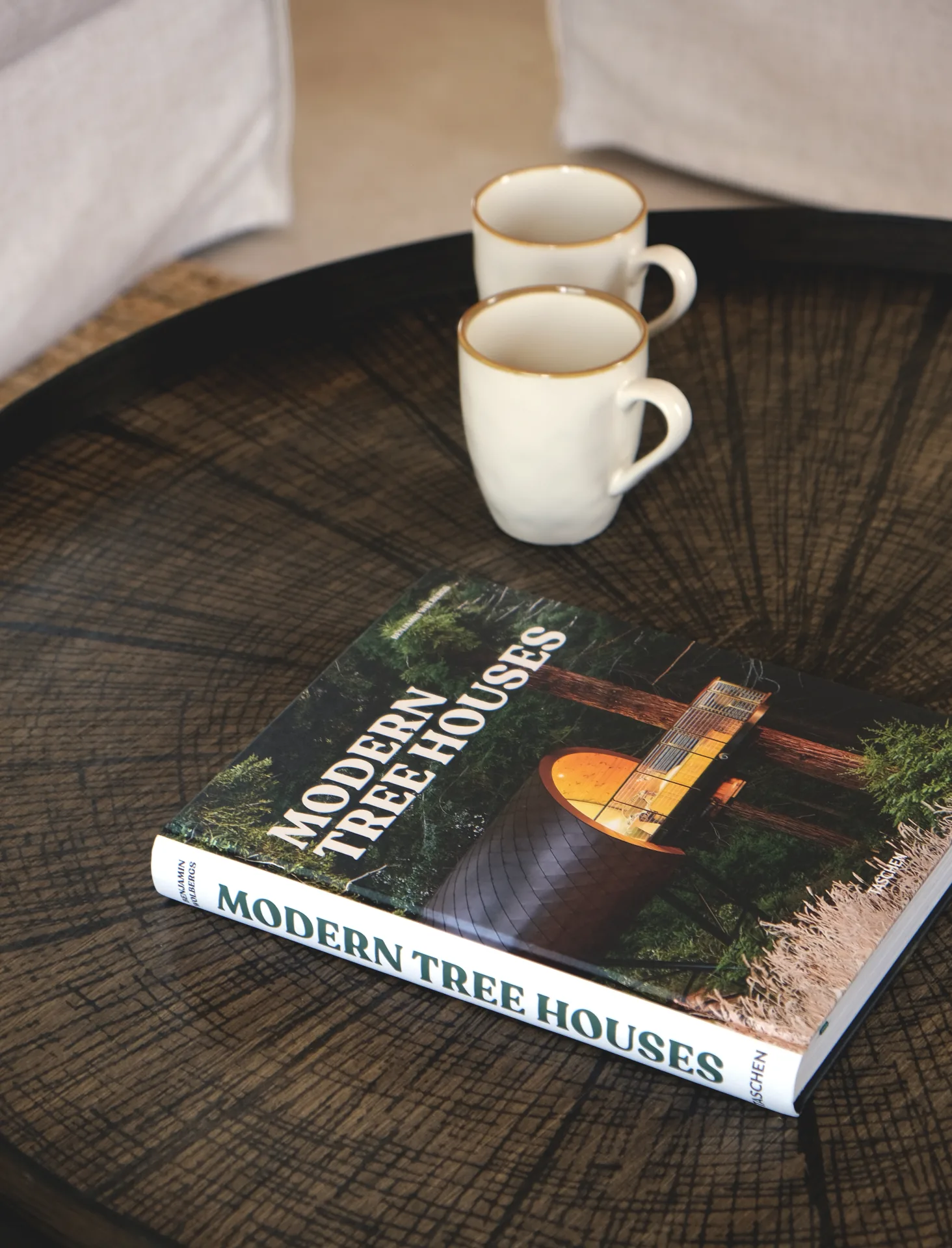 Mesa auxiliar de madera oscura con tazas y libro de arquitectura Mesa auxiliar de madera oscura con tazas y libro de arquitectura
