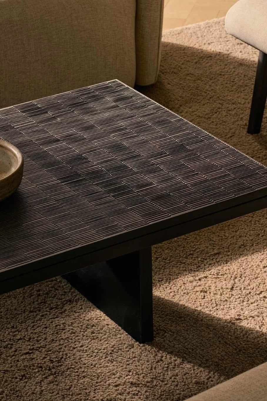 Mesa de centro de madera con un cuenco de cerámica sobre una alfombra Mesa de centro de madera con un cuenco de cerámica sobre una alfombra