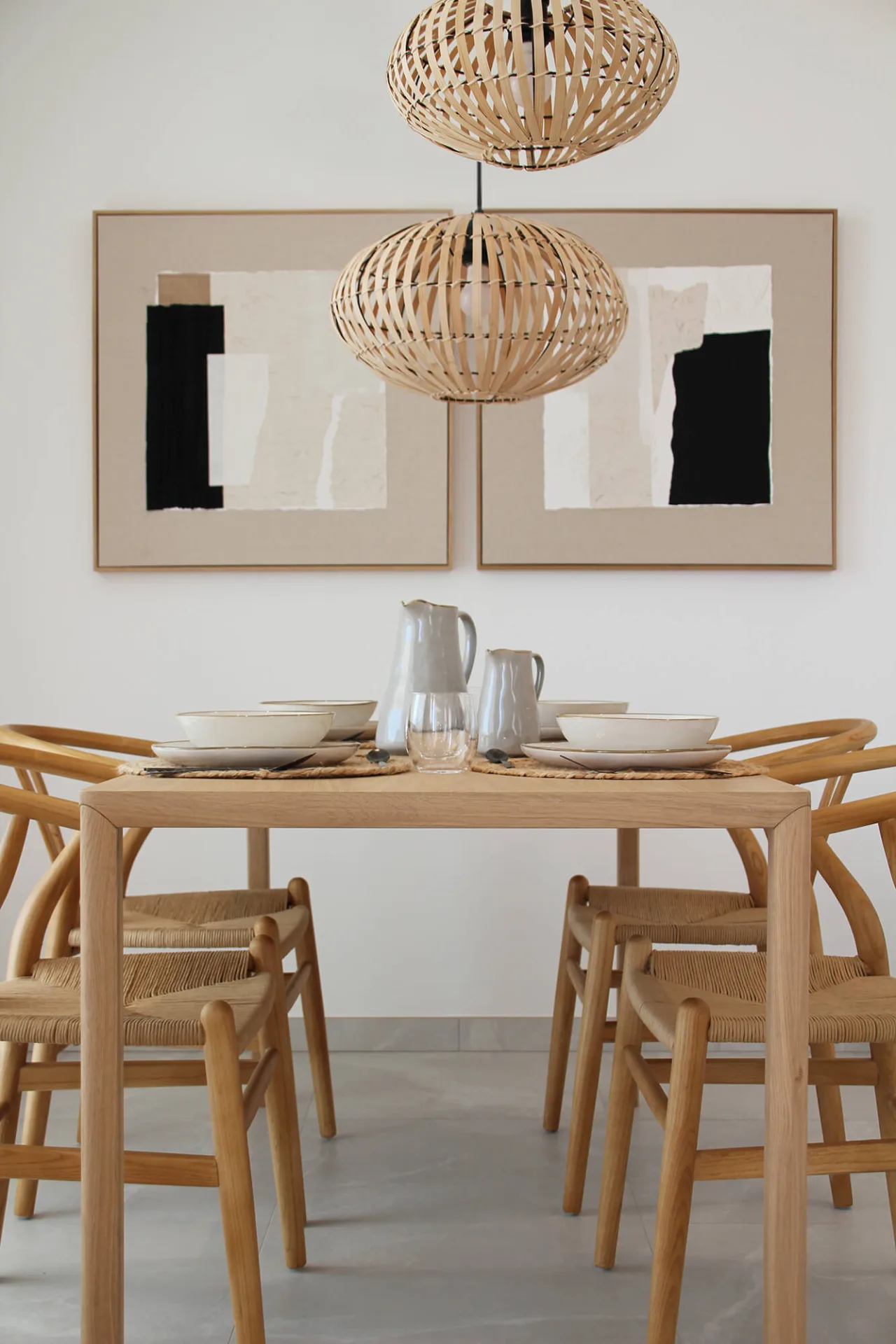 Mesa de comedor de madera con sillas de fibra bajo lámparas de mimbre Mesa de comedor de madera con sillas de fibra bajo lámparas de mimbre