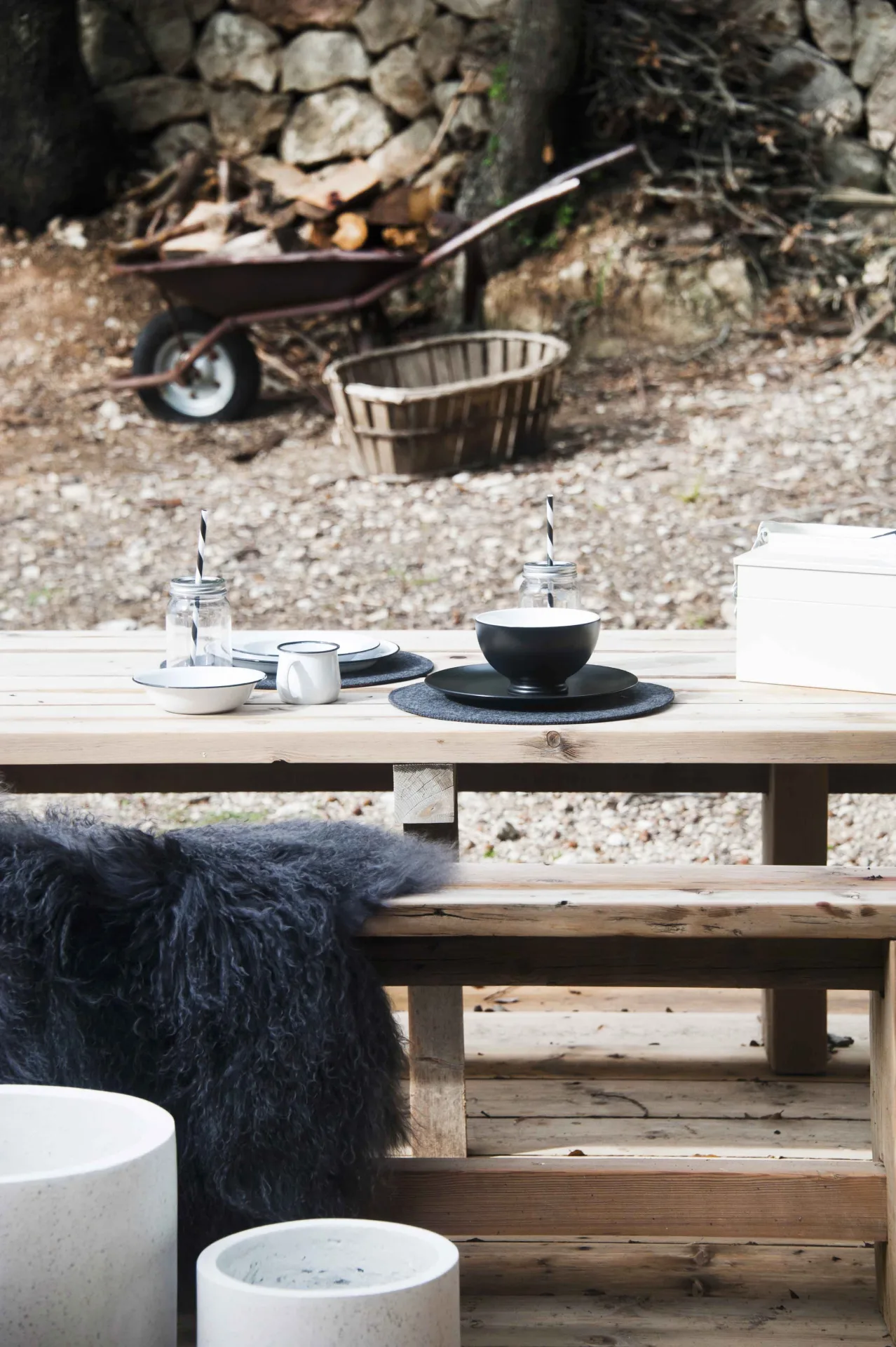 Outdoor wooden table set with dark tableware