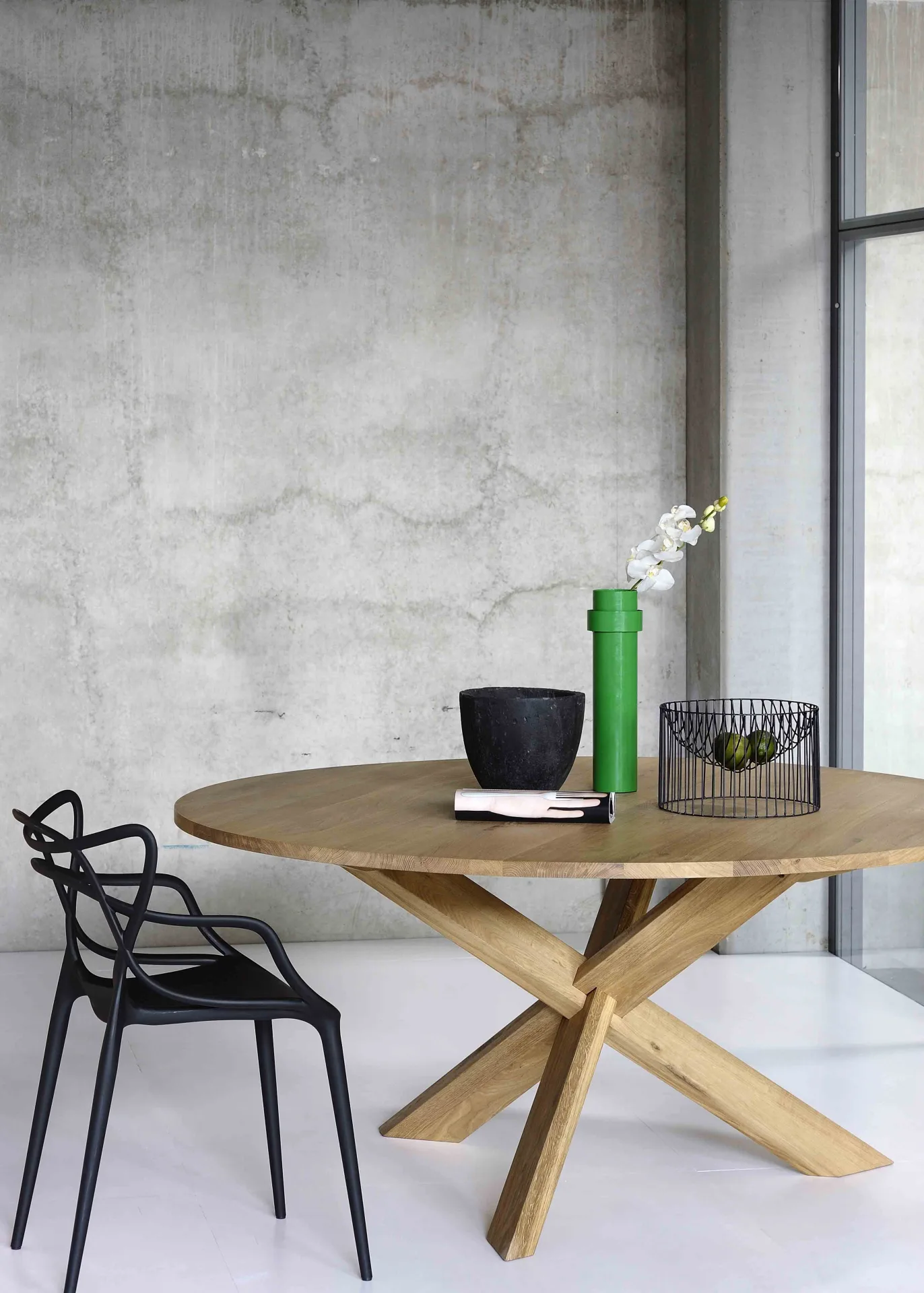 Round wooden table with a black chair and decorative objects