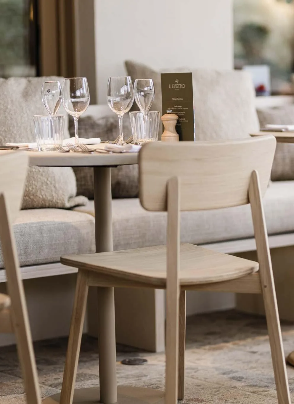 Mesas de restaurante con sillas de madera y copas Mesas de restaurante con sillas de madera y copas