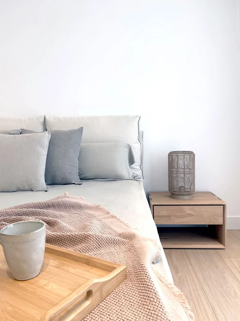 Mesilla de madera y lámpara junto a la cama Mesilla de madera y lámpara junto a la cama