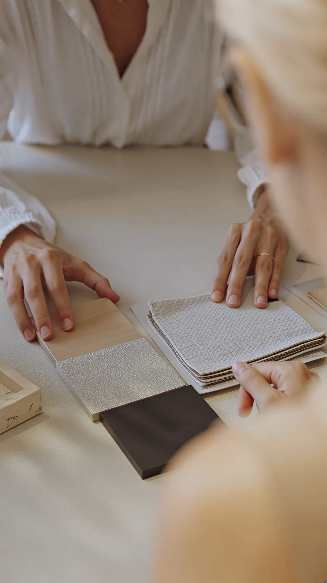 Manos sobre muestras de materiales y planos en el estudio de interiorismo de Palma