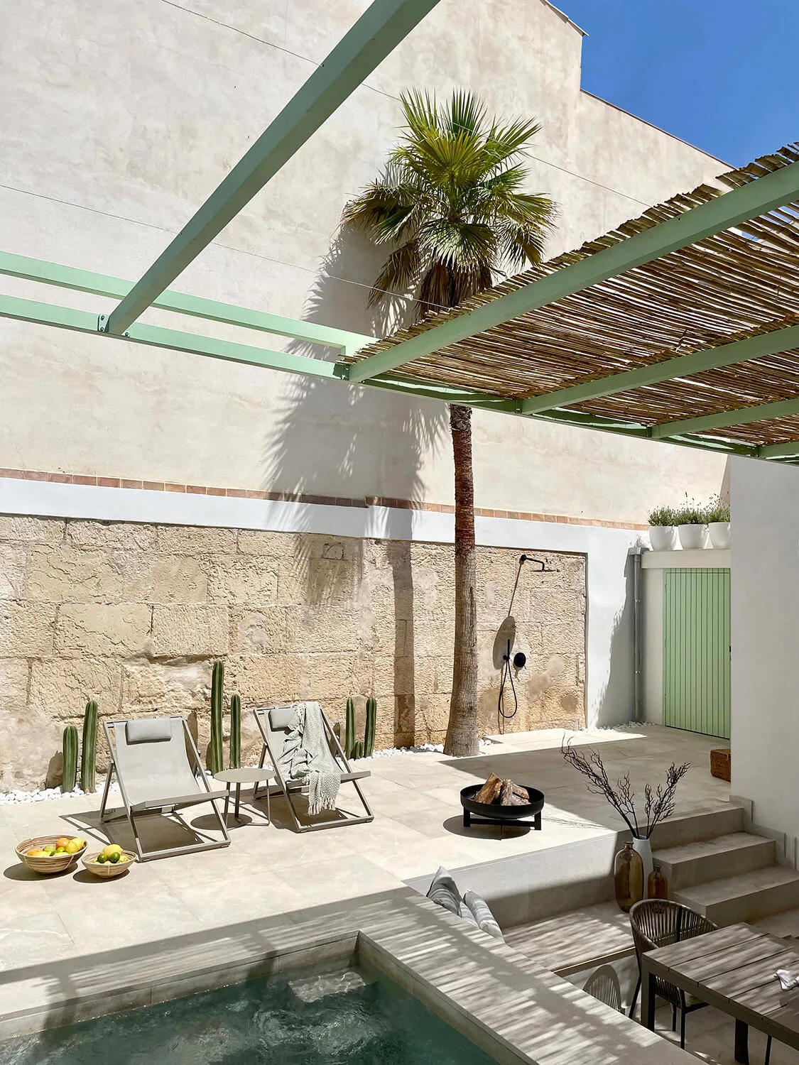 Innenhof mit Steinmauer, Palme, Schilfpergola und Pool in einem Haus in der Colònia de Sant Jordi