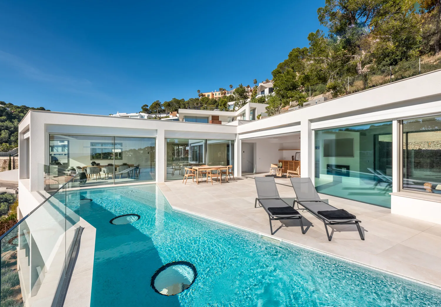 Infinity-Pool, Sonnenliegen und verglaste Veranda einer Villa in Costa d'en Blanes