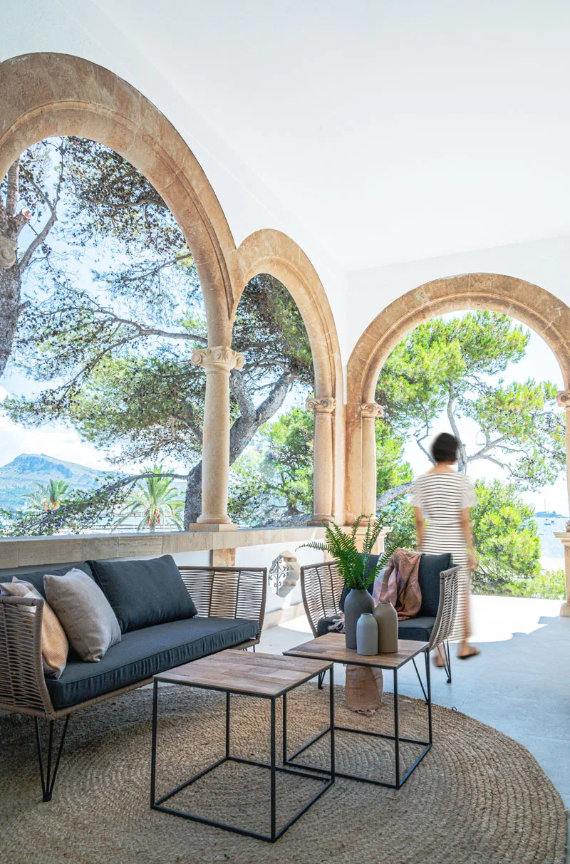 Veranda mit Steinbögen, Outdoor-Sofa und Beistelltischen mit Blick aufs Meer in Puerto Pollença