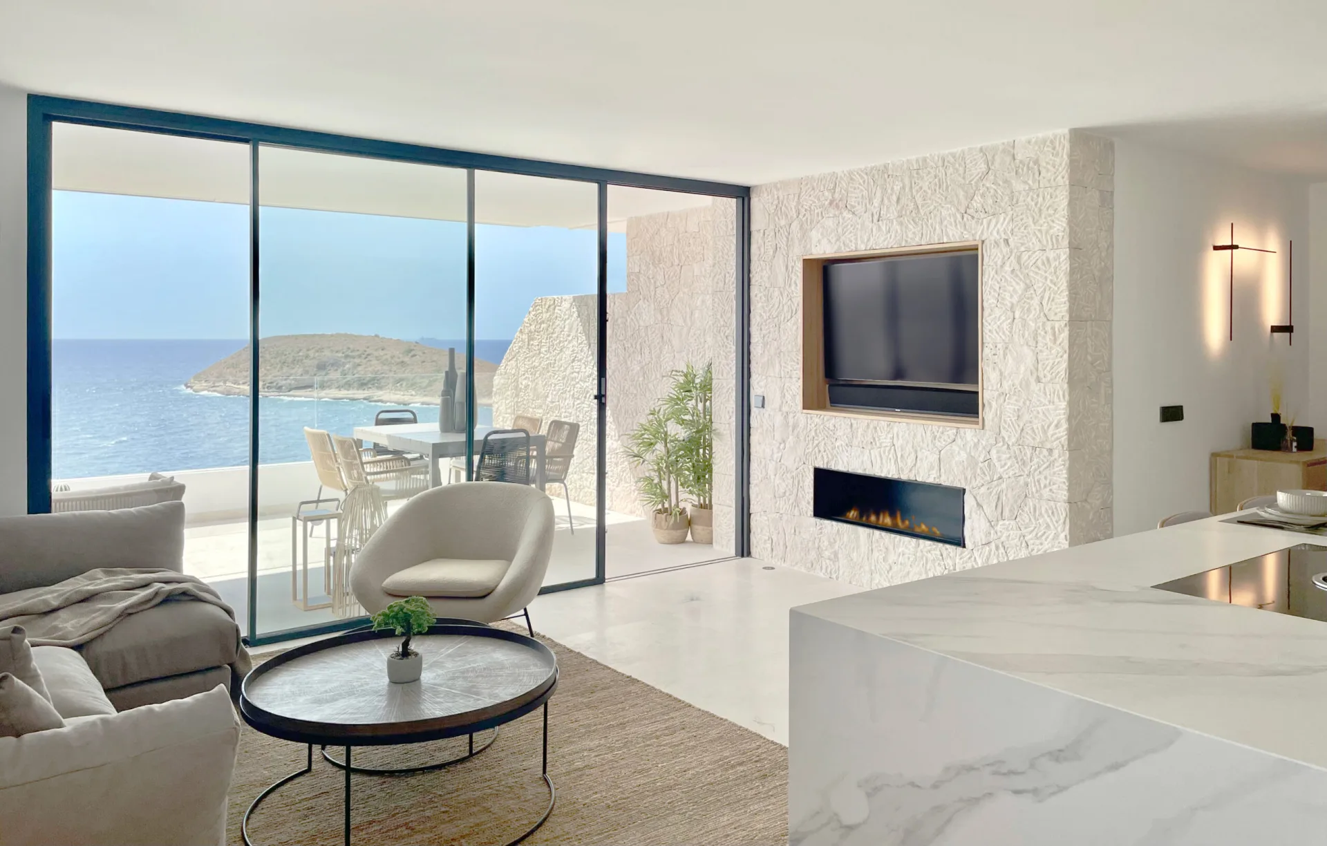 Salón con chimenea y vistas al mar en un dúplex de Torrenova