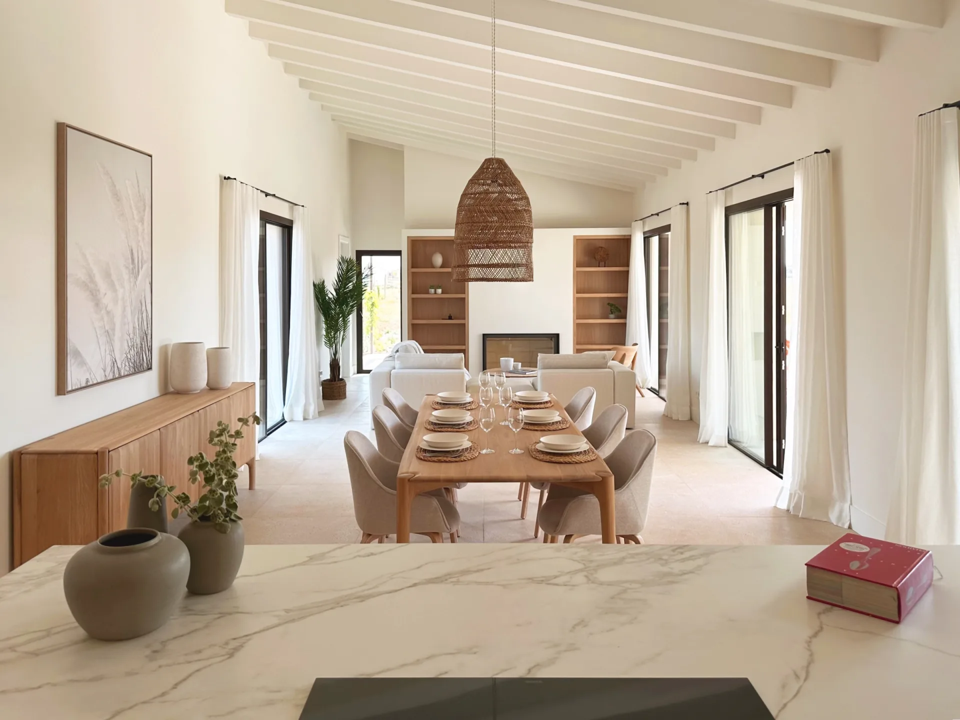 Salón comedor con techo de vigas blancas y encimera de mármol Salón comedor con techo de vigas blancas y encimera de mármol