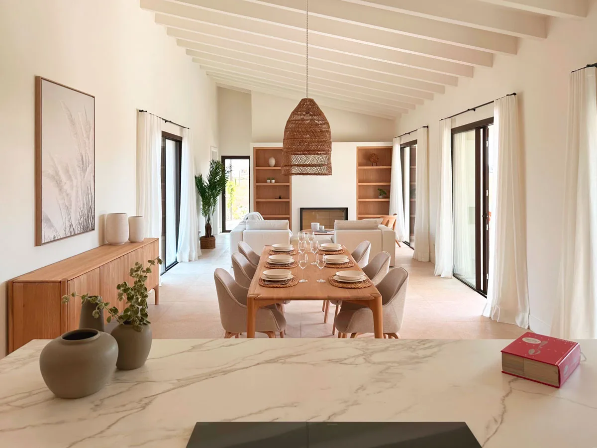 Wohn- und Essbereich mit weißen Balken, Holztisch und geflochtener Pendelleuchte im Haus Estela Blava in Sa Ràpita