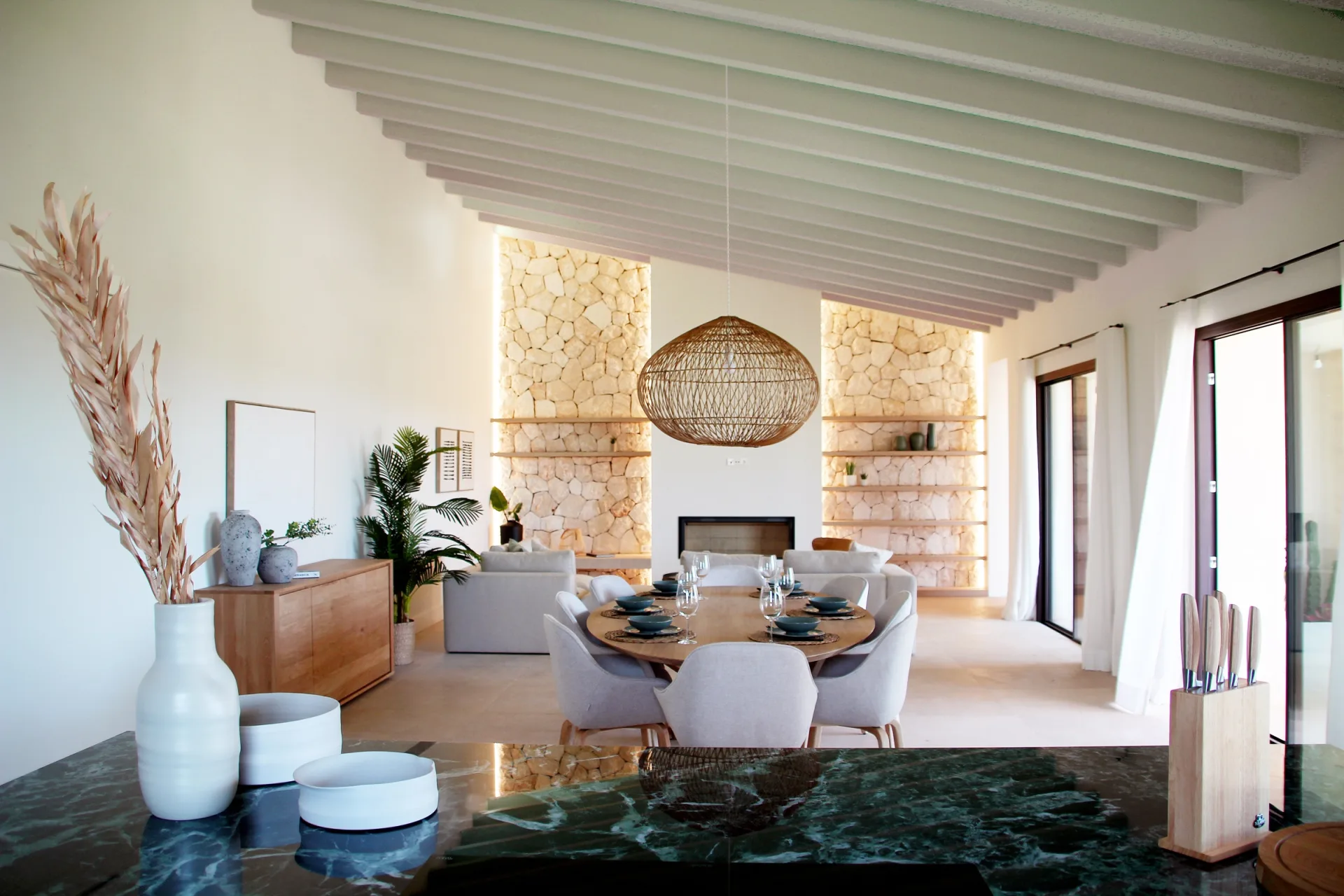 Salón comedor con vigas inclinadas y encimera de mármol verde Salón comedor con vigas inclinadas y encimera de mármol verde