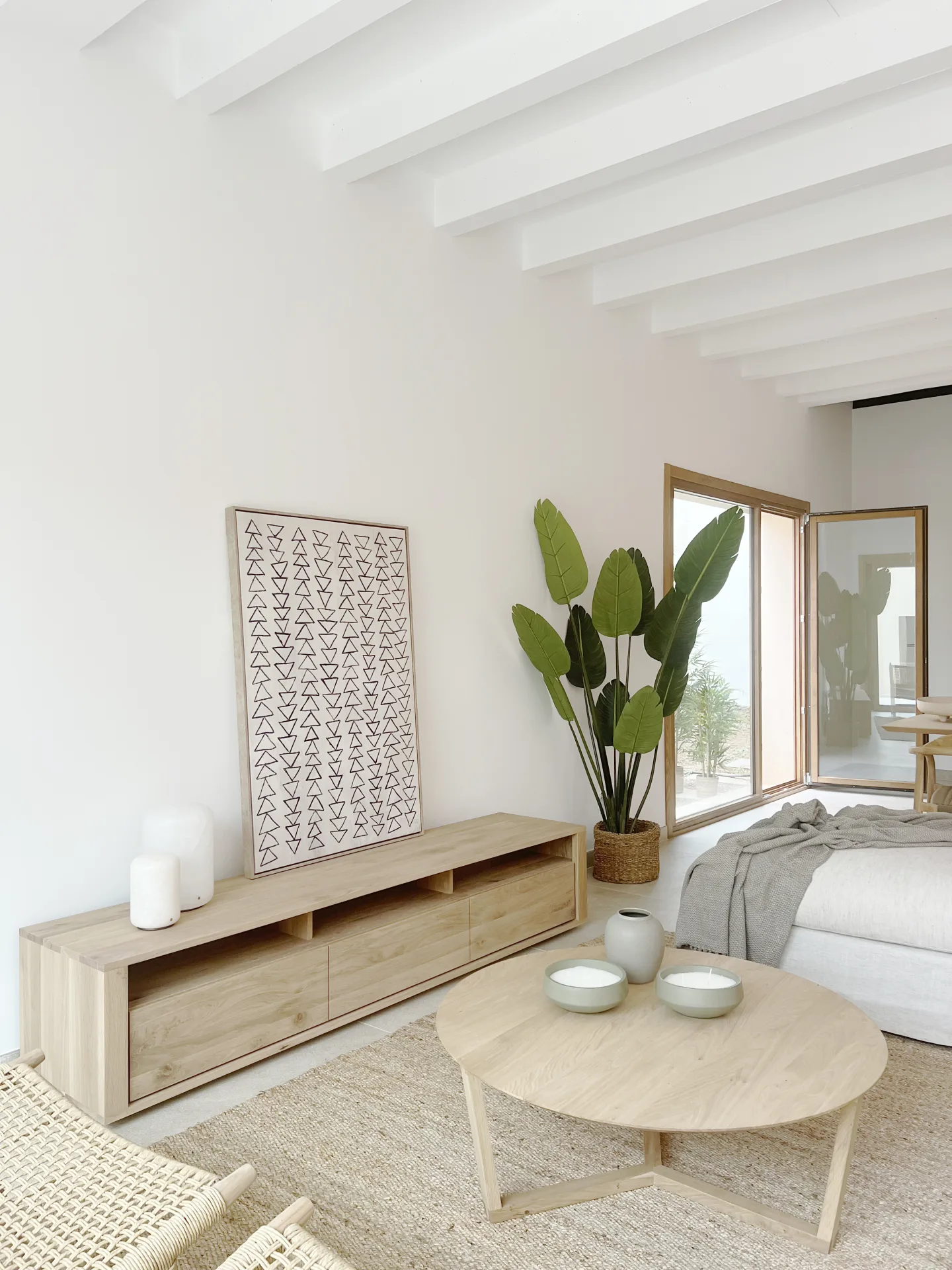Salón con mueble de madera, mesa de centro redonda y cuadro Salón con mueble de madera, mesa de centro redonda y cuadro