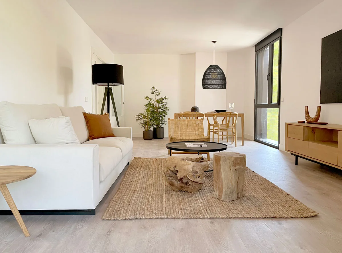Salón con sofá blanco, lámpara de pie y comedor al fondo Salón con sofá blanco, lámpara de pie y comedor al fondo