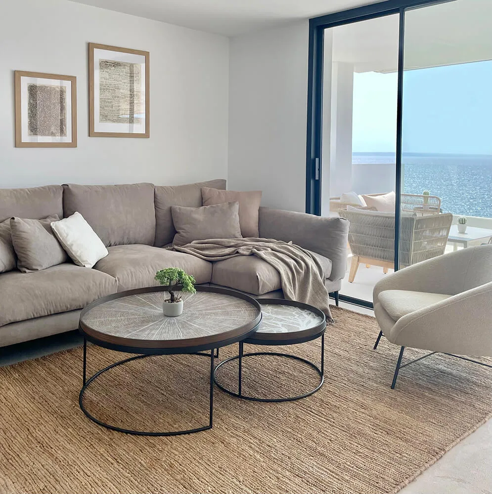 Salón con sofá gris, mesas de centro y cuadros Salón con sofá gris, mesas de centro y cuadros