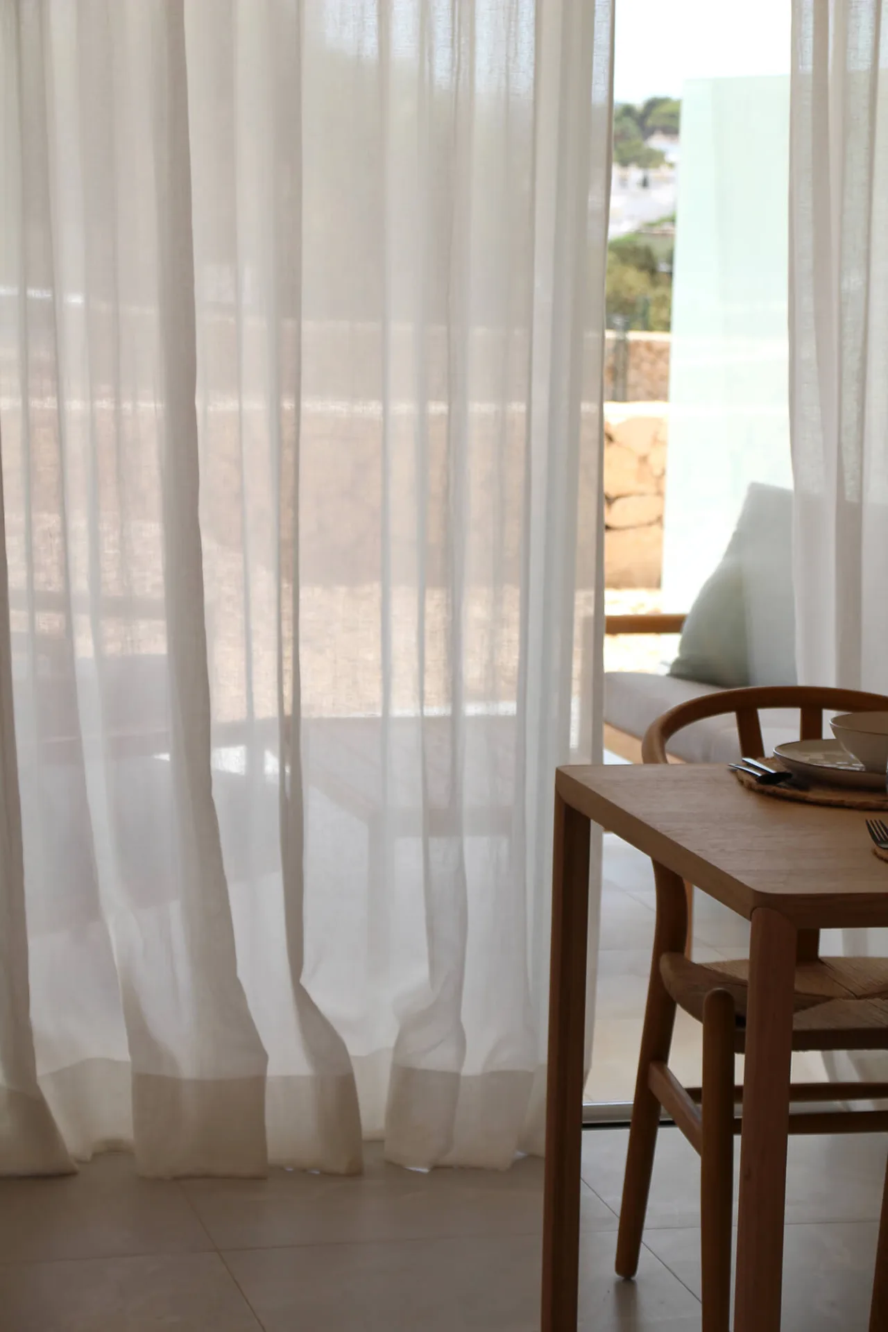Silla de madera junto a cortinas blancas de lino Silla de madera junto a cortinas blancas de lino