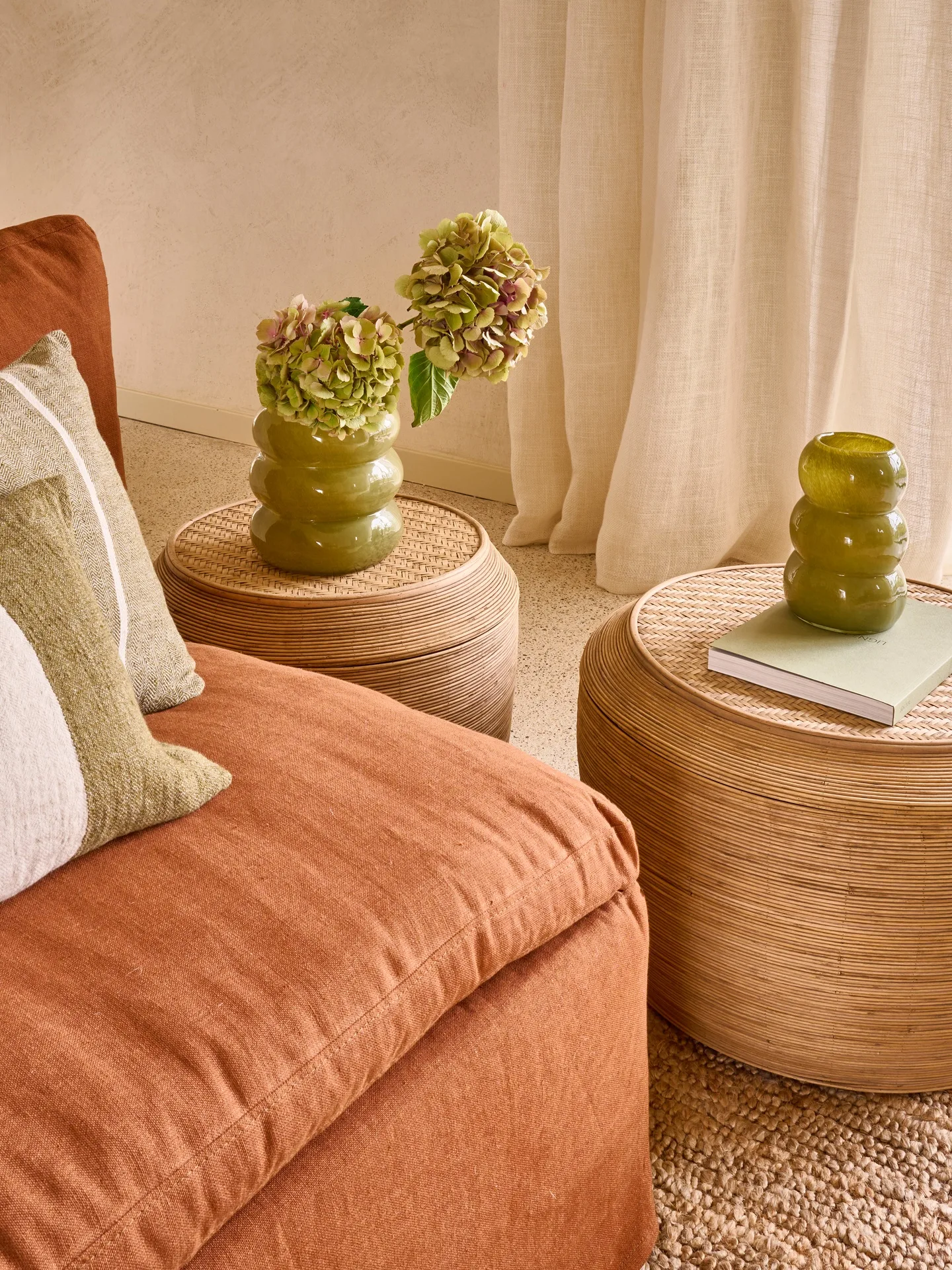 Sofá terracota con cojines y mesa auxiliar de fibra con jarrón Sofá terracota con cojines y mesa auxiliar de fibra con jarrón