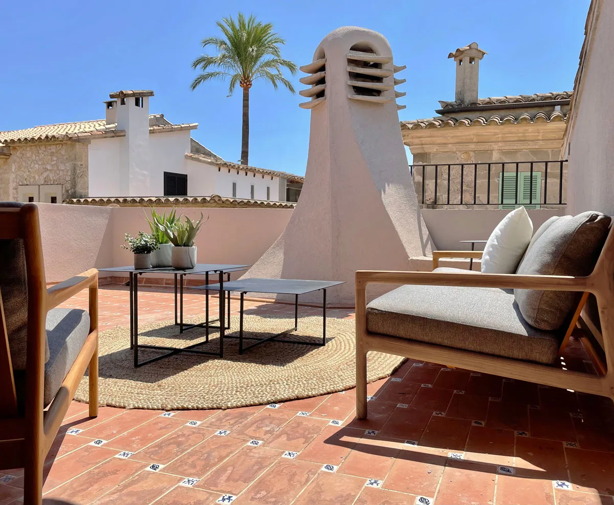 Terraza con chimenea y butaca de madera sobre los tejados de Pollença Terraza con chimenea y butaca de madera sobre los tejados de Pollença