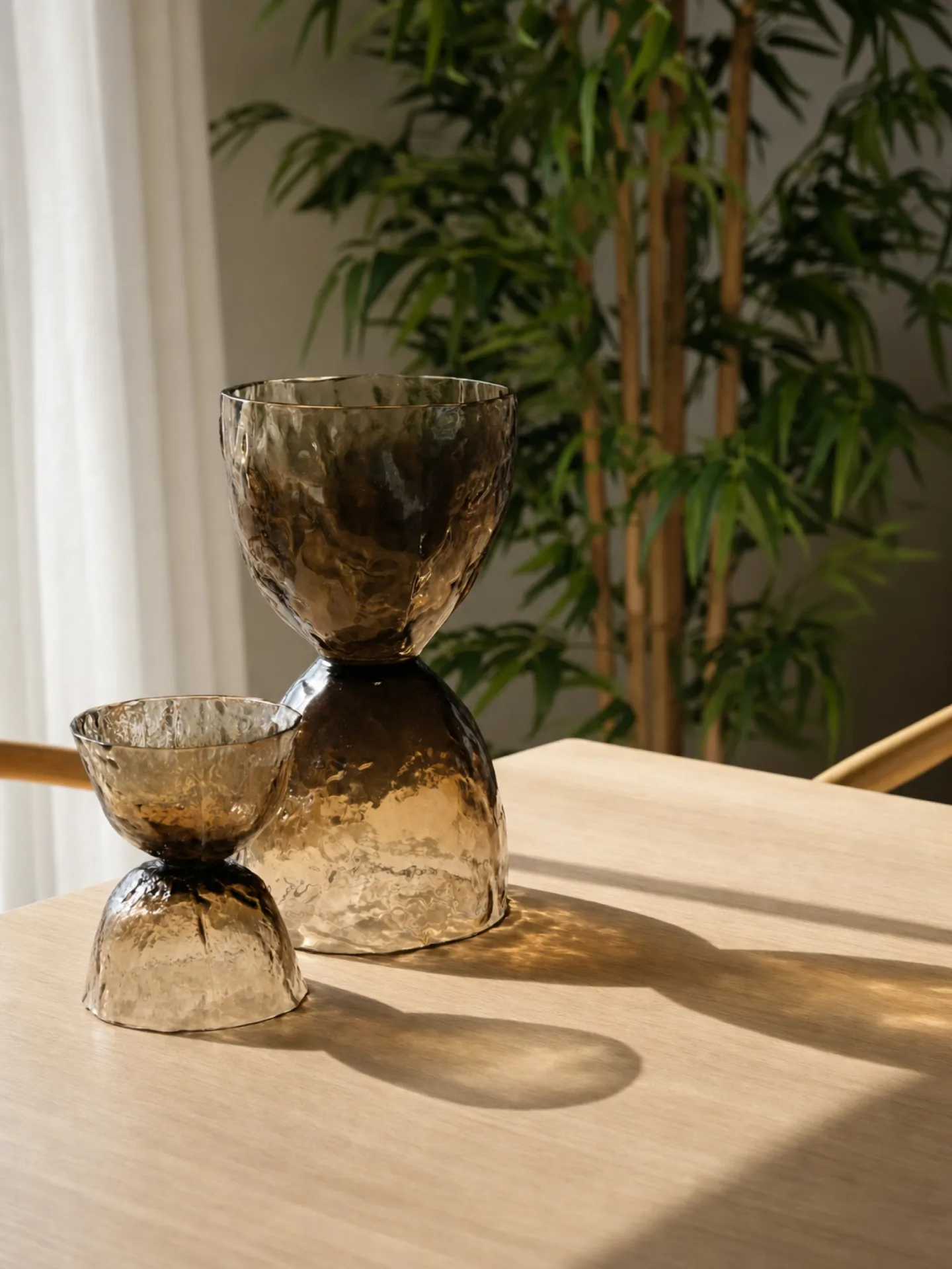 Vaso de cristal ahumado sobre mesa de madera junto a una planta Vaso de cristal ahumado sobre mesa de madera junto a una planta